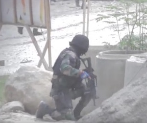 A police officer takes cover as shots are fired during efforts to disperse rallying farmers in Kidapawan.