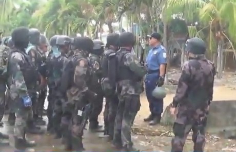 Heavily-armed Philippine Police officers regroup after rallying farmers are forcibly dispersed in Kidapawan.